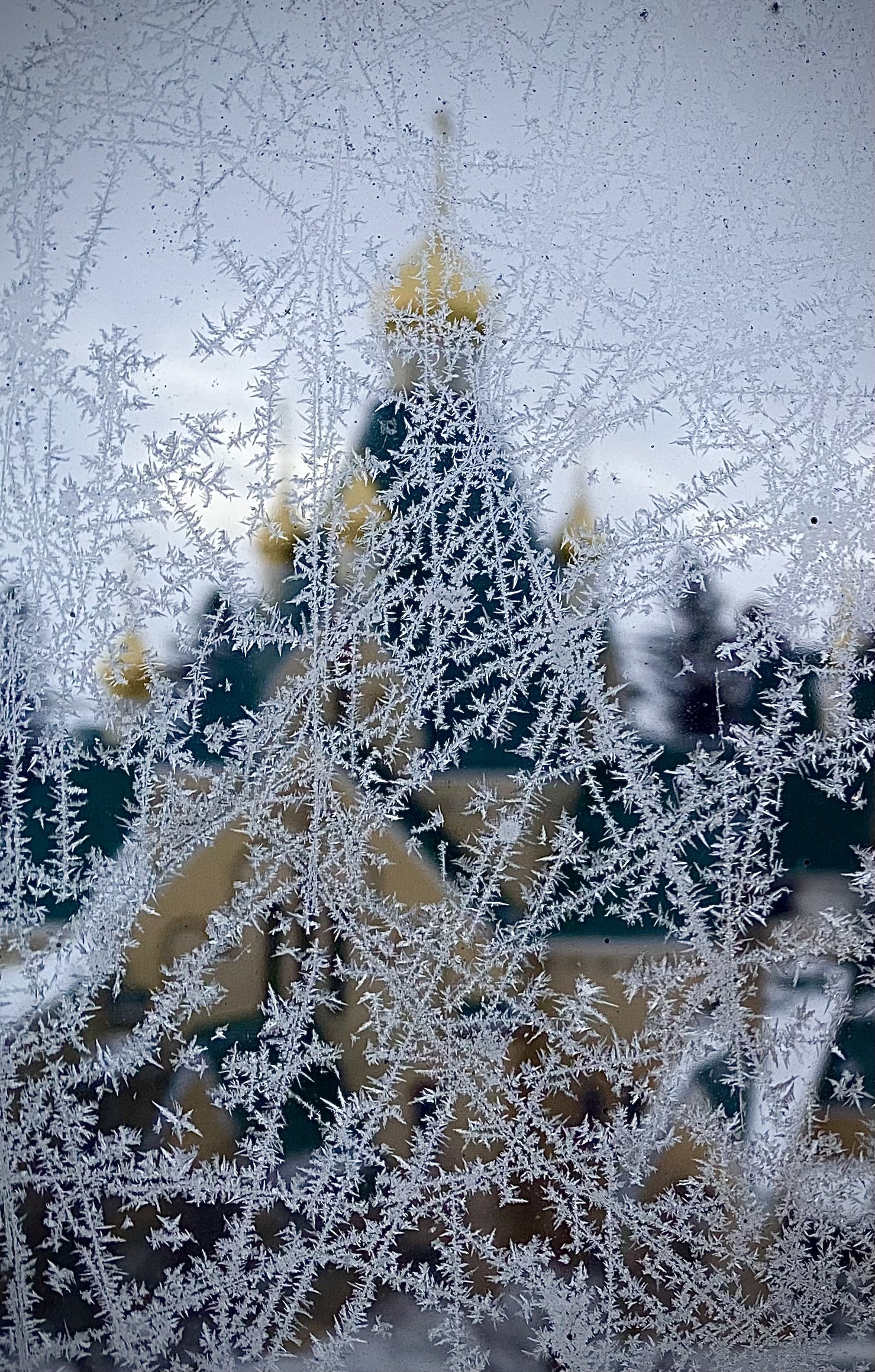 A blurry Orthodox church seen through a an icy window